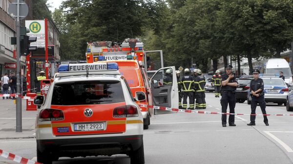 Police officers and fire engines stand in front of the supermarket in Hamburg, Germany, Friday, July 28, 2017, where a man with a knife fatally stabbed one person and wounded four others as he fled, police said - Sputnik International