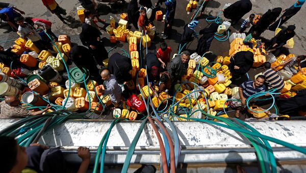 People gather to fill up their jerrycans with drinking water from a charity tanker truck, amid a cholera outbreak, in Sanaa, Yemen, July 12, 2017. - Sputnik International