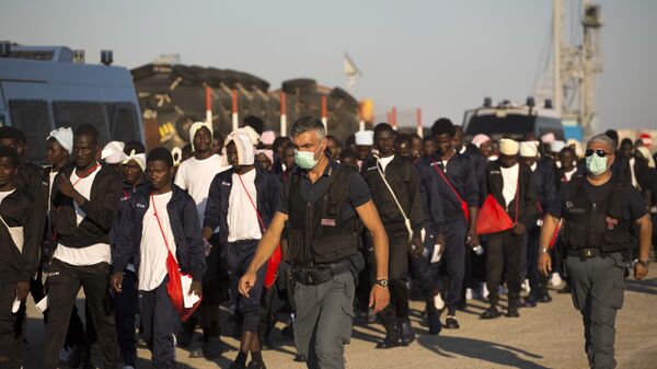 Italian border police officers escort sub Saharan men on their way to a relocation center, after arriving in the Golfo Azzurro rescue vessel at the port of Augusta, in Sicily, Italy, with hundreds of migrants aboard, rescued by members of Proactive Open Arms NGO, on Friday, June 23, 2017 - Sputnik International