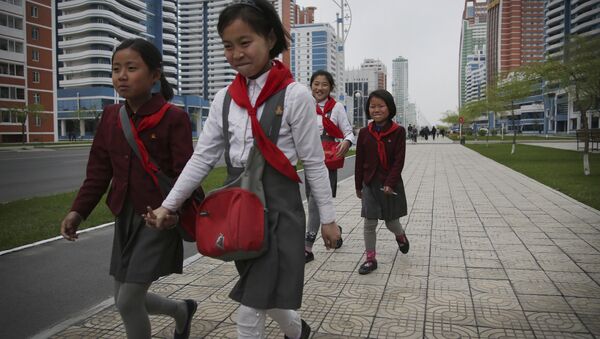 North Korean school girls hold back their laughter at seeing their photograph being taken while walking along Mirae Scientists Street on Wednesday, April 19, 2017, in Pyongyang, North Korea - Sputnik International