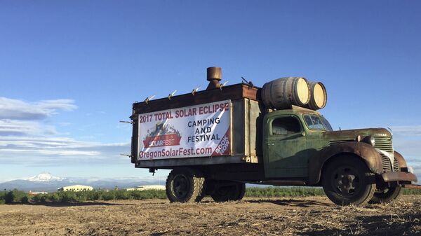 An advertisement for a festival built around the Aug. 21 total solar eclipse sits alongside a busy road leading into Madras, Oregon on June 13, 2017. The first place to experience total darkness as the moon passes between the sun and the Earth will be in Oregon and Madras, in the central part of the state, is expected to be a prime viewing location. Up to 1 million people are expected in Oregon for the first coast-to-coast total solar eclipse in 99 years and up to 100,000 could show up in Madras and surrounding Jefferson County. Officials are worried about the ability of the rural area to host so many visitors and are concerned about the danger of wildfire from so many people camping on public lands. - Sputnik International