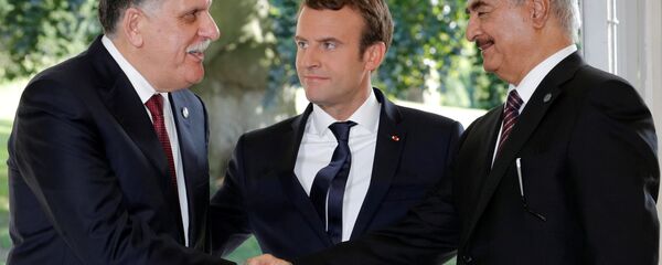 French President Emmanuel Macron stands between Libyan Prime Minister Fayez al-Sarraj (L), and General Khalifa Haftar (R), commander in the Libyan National Army (LNA), who shake hands after talks over a political deal to help end Libya’s crisis in La Celle-Saint-Cloud near Paris, France, July 25, 2017 French President Emmanuel Macron stands between Libyan Prime Minister Fayez al-Sarraj (L), and General Khalifa Haftar (R), commander in the Libyan National Army (LNA), who shake hands after talks over a political deal to help end Libya’s crisis in La Celle-Saint-Cloud near Paris, France, July 25, 2017 - Sputnik International