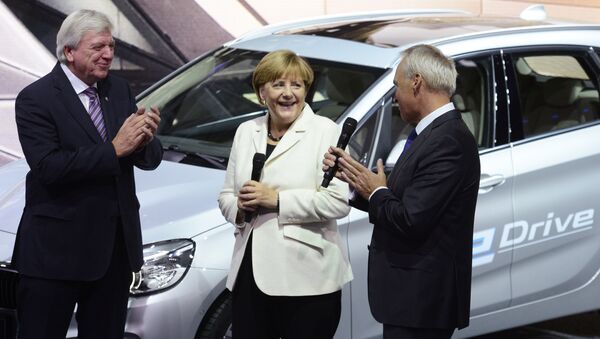 German Chancellor Angela Merkel talks to BMW CFO Friedrich Eichiner, right, as Hesse state governor Volker Bouffier, left, applauds on the first day of the Frankfurt Auto Show IAA in Frankfurt, Germany, Thursday, September 17, 2015. - Sputnik International