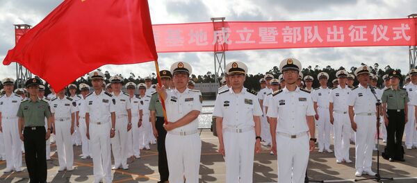 A soldier of China's People's Liberation Army (PLA) is holding a PLA flag as others stand guard at a military port in Zhanjiang, Guangdong province, China, July 11, 2017 - Sputnik International