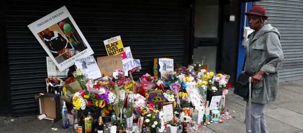A woman looks at floral tributes laid after the death of Rashan Charles outside a shop in east London A woman looks at floral tributes laid after the death of Rashan Charles outside a shop in east London - Sputnik International