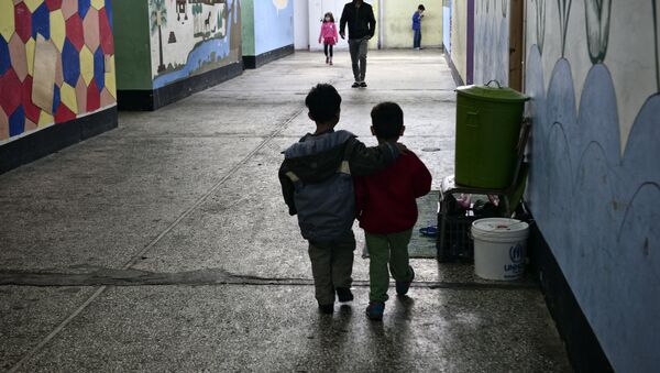 Children walk through a former industrial warehouse at the Oinofyta refugee camp, some 60 km north of Athens, on March 13, 2017 in Oinofyta - Sputnik International