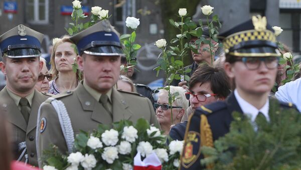 A Polish Army junior officers and Warsaw residents hold flowers during a ceremony to unveil a monument for for World War II hero, Capt. Witold Pilecki, who volunteered to go to Auschwitz and report on the atrocities there, and was later killed by Poland's communist regime,, in Warsaw, Poland, Saturday, May 13, 2017. - Sputnik International