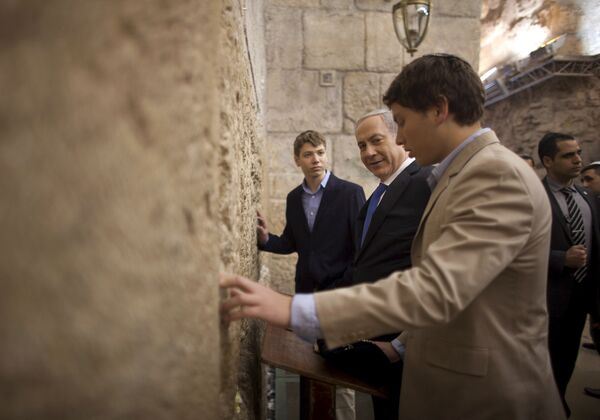 In this Jan. 22, 2013 file photo, Israeli Prime Minister Benjamin Netanyahu, center, prays with his sons Yair, background, and Avner, right, at the Western Wall, the holiest site where Jews can pray, in Jerusalem's Old City. In this Jan. 22, 2013 file photo, Israeli Prime Minister Benjamin Netanyahu, center, prays with his sons Yair, background, and Avner, right, at the Western Wall, the holiest site where Jews can pray, in Jerusalem's Old City. - Sputnik International