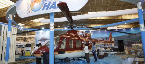Workers polish a helicopter at the stall of Hindustan Aeronautics Ltd. on the eve of Aero India 2011 at Yelahanka air base on the outskirts of Bangalore, India. (File) - Sputnik International