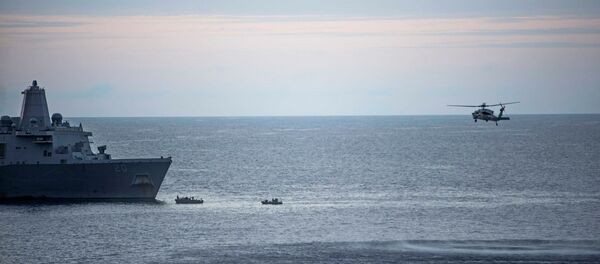 In this Saturday, Aug. 5, 2017, sailors man small boats as an MH-60S Sea Hawk helicopter, assigned to Helicopter Sea Combat Squadron (HSC) 25 flies overhead to recover personnel near the amphibious transport dock USS Green Bay (LPD 20) following an aviation mishap of an MV-22 Osprey, which caused the aircraft to enter the water off the coast of Australia. - Sputnik International