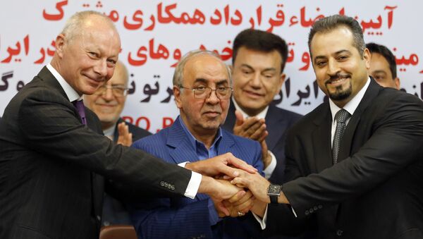 (L to R) Thierry Bollore, deputy director of Competitiveness at Renault, Mansour Moazami, Chairman of the Board of Directors of IDRO Group, and Kourosh Morshed Solouk, deputy director of the Iranian Automobile Importers Association, shake hands as they attend a signing of a deal ceremony in Tehran on August 7, 2017 - Sputnik International