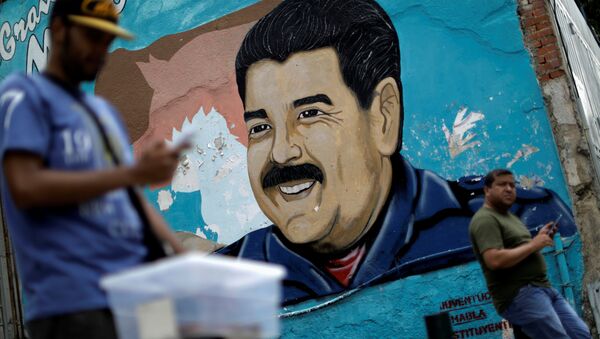 A man walks past a portrait of Venezuela's President Nicolas Maduro in Caracas, Venezuela August 7, 2017. - Sputnik International