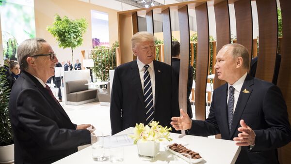 In this photo provided by German government U.S. President Donald Trump, center, talks to Russian President Vladimir Putin and European Commission President Jean-Claude Juncker, left, before the first working session of the G-20 summit in Hamburg, northern Germany. - Sputnik International