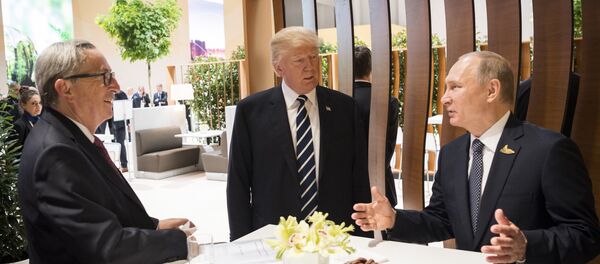 In this photo provided by German government U.S. President Donald Trump, center, talks to Russian President Vladimir Putin and European Commission President Jean-Claude Juncker, left, before the first working session of the G-20 summit in Hamburg, northern Germany. - Sputnik International