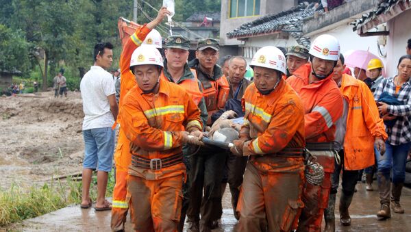 Rescue workers carry an injured villager at the site of a landslide that occurred in Gengdi village, Puge county, Sichuan province, China August 8, 2017 - Sputnik International