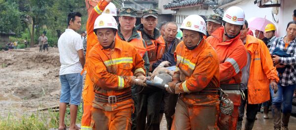 Rescue workers carry an injured villager at the site of a landslide that occurred in Gengdi village, Puge county, Sichuan province, China August 8, 2017 - Sputnik International