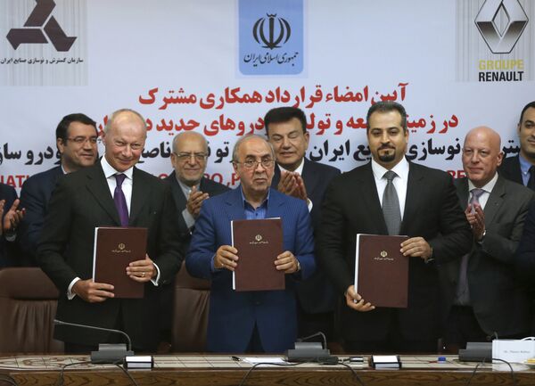 Chief Competitive Officer of Groupe Renault Thierry Bolloré, left, Chairman of Industrial Development and Renovation Oraganization of Iran, IDRO, Mansour Moazami, center, and Negin Group CEO Kourosh Morshed Solouk join shows documents to media after signing a deal in Tehran, Iran, Monday, Aug. 7, 2017 Chief Competitive Officer of Groupe Renault Thierry Bolloré, left, Chairman of Industrial Development and Renovation Oraganization of Iran, IDRO, Mansour Moazami, center, and Negin Group CEO Kourosh Morshed Solouk join shows documents to media after signing a deal in Tehran, Iran, Monday, Aug. 7, 2017 - Sputnik International