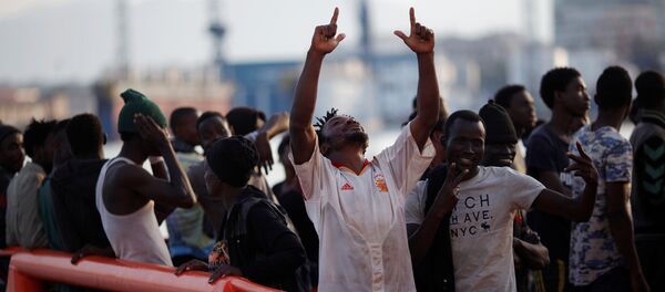 A migrant, who is part of a group intercepted aboard a dinghy off the coast in the Mediterranean sea, reacts on a rescue boat upon arriving at a port in Malaga, Spain August 7, 2017 - Sputnik International