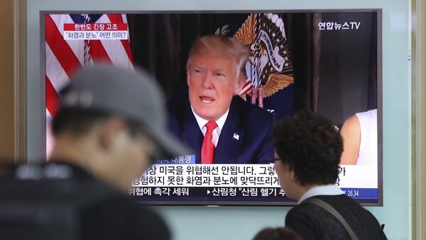 People walk by a TV screen showing a local news program reporting with an image of U.S. President Donald Trump at the Seoul Train Station in Seoul, South Korea, Wednesday, Aug. 9, 2017 - Sputnik International