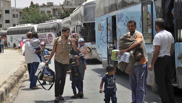 This photo released Tuesday, July 11, 2017 by the Syrian official news agency SANA, shows Syrians arriving from Jarablus, in Aleppo province, to their old neighborhood of al-Waer, in Homs, Syria - Sputnik International