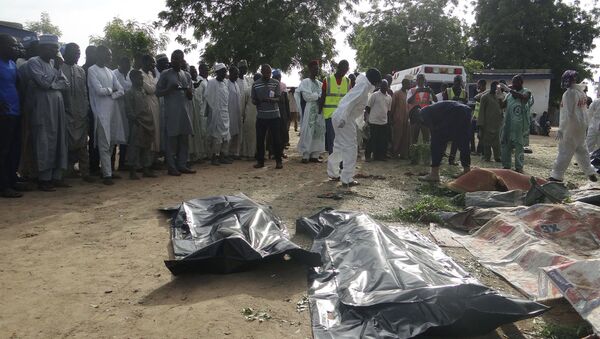 People mourn over the bodies of suicide bomb attack victims in a village near Maiduguri, Nigeria, Wednesday, July 12, 2017 - Sputnik International