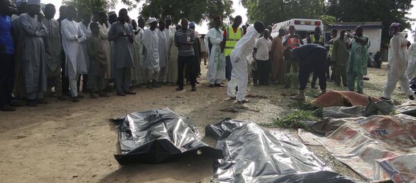 People mourn over the bodies of suicide bomb attack victims in a village near Maiduguri, Nigeria, Wednesday, July 12, 2017 - Sputnik International
