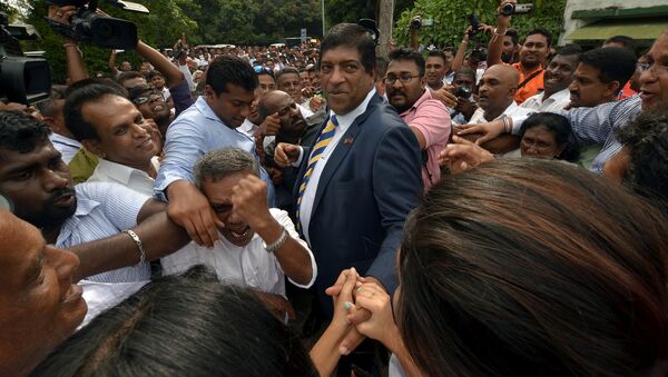 Sri Lanka's foreign minister Ravi Karunanayake reacts as he is surrounded by his supporters after he resigned on Thursday over corruption charges, in Colombo, Sri Lanka August 10, 2017 - Sputnik International