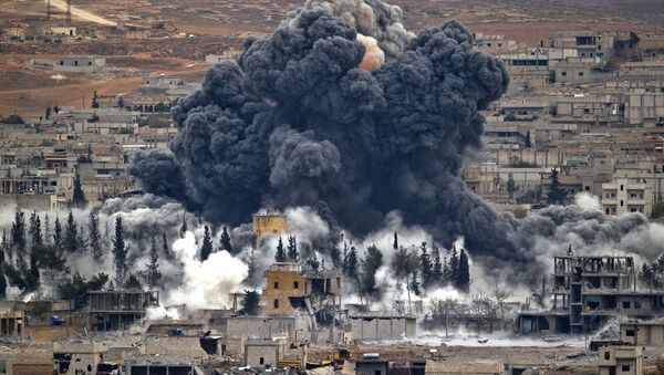 In this Nov. 17, 2014 file photo, smoke rises from the Syrian city of Kobani, following an airstrike by the U.S.-led coalition, seen from a hilltop outside Suruc, on the Turkey-Syria border. - Sputnik International