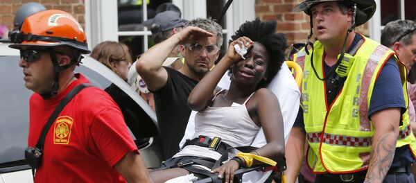 Rescue personnel help an injured woman after a car ran into a large group of protesters after an white nationalist rally in Charlottesville, Va., Saturday, Aug. 12, 2017. Rescue personnel help an injured woman after a car ran into a large group of protesters after an white nationalist rally in Charlottesville, Va., Saturday, Aug. 12, 2017. - Sputnik International