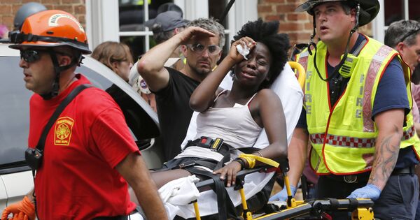 Rescue personnel help an injured woman after a car ran into a large group of protesters after an white nationalist rally in Charlottesville, Va., Saturday, Aug. 12, 2017. - Sputnik International