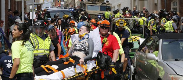 Rescue personnel help injured people after a car ran into a large group of protesters after a white nationalist rally in Charlottesville, Va., Saturday, Aug. 12, 2017. Rescue personnel help injured people after a car ran into a large group of protesters after a white nationalist rally in Charlottesville, Va., Saturday, Aug. 12, 2017. - Sputnik International