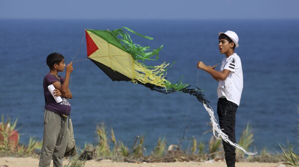 Palestinian youths fly their kites during a Hamas-sponsored summer scout camp, in an event held as a show of support against Israeli security measures installing metal detectors at the Al Aqsa Mosque compound in Jerusalem, on the beach near the Israeli border fence, in Beit Lahiya, northern Gaza Strip, Wednesday, July 19, 2017. - Sputnik International
