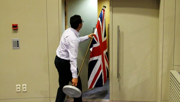 An official carries a Union Jack flag ahead of a news conference by Britain's Secretary of State for Exiting the European Union David Davis and European Union's chief Brexit negotiator Michel Barnier in Brussels, Belgium July 20, 2017 - Sputnik International