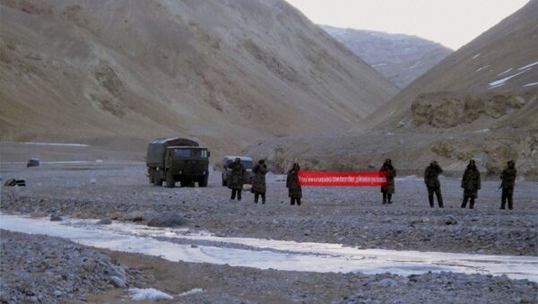 (File) In this May 5, 2013 file photo, Chinese troop hold a banner which reads, You've crossed the border, please go back, in Ladakh, India - Sputnik International
