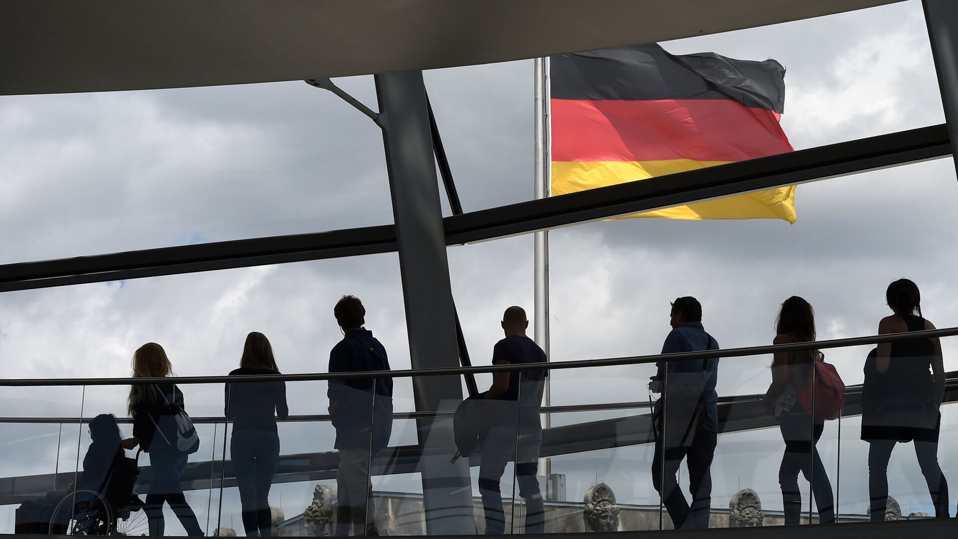 Visitors walk in the glass cupola of the Reichstag building that hosts the German parliament (Bundestag) and look at a German flag in Berlin, Germany, on June 10, 2016. - Sputnik International, 1920, 14.03.2023
