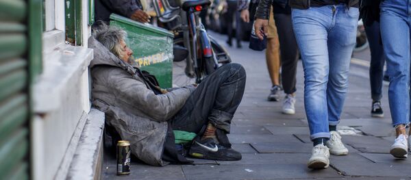 A group of people walks past homeless people on Broadway Market in east London on July 23, 2017 A group of people walks past homeless people on Broadway Market in east London on July 23, 2017 - Sputnik International