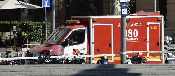 A policeman stands next to an ambulance after a van ploughed into the crowd, injuring several persons on the Rambla in Barcelona on August 17, 2017 - Sputnik International