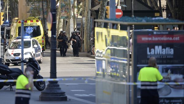 Armed policemen arrive in a cordoned off area after a van ploughed into the crowd, injuring several persons on the Rambla in Barcelona on August 17, 2017 - Sputnik International
