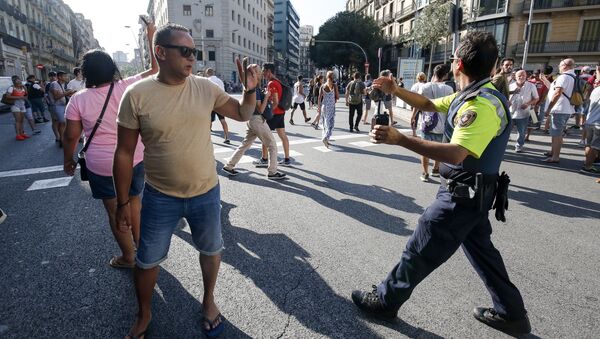 A policeman asks people to move back near a cordoned off area after a van ploughed into the crowd, killing one person and injuring several others on the Rambla in Barcelona on August 17, 2017 - Sputnik International