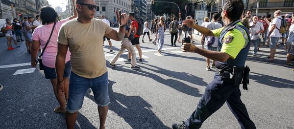 A policeman asks people to move back near a cordoned off area after a van ploughed into the crowd, killing one person and injuring several others on the Rambla in Barcelona on August 17, 2017 - Sputnik International