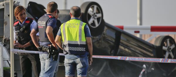 Police officers stand near an overturned car onto a platform at the spot where terrorists were intercepted by police in Cambrils, Spain, Friday, Aug. 18, 2017 - Sputnik International
