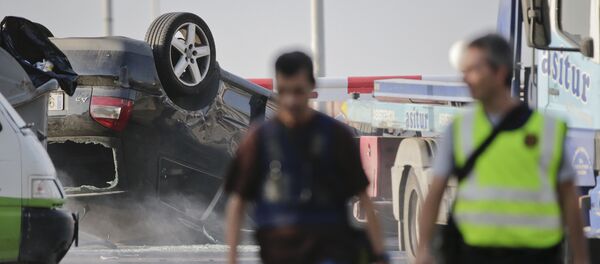 Police officers walk near an overturned car onto a platform at the spot where terrorists were intercepted by police in Cambrils, Spain, Friday, Aug. 18, 2017 - Sputnik International
