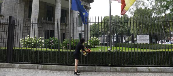 The Spanish and the European flag fly at half mast as a woman fixes flowers at the fence of the Spanish embassy in Berlin, on August 18, 2017 in tribute to victims of the Barcelona attack The Spanish and the European flag fly at half mast as a woman fixes flowers at the fence of the Spanish embassy in Berlin, on August 18, 2017 in tribute to victims of the Barcelona attack - Sputnik International