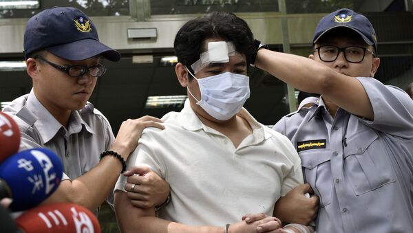 A suspect identified only by his family name Lu (C), is escorted by policemen at a local police bureau in Taipei on August 18, 2017, after he was suspected of slashing a police guard with a Samurai sword at the Presidential Palace - Sputnik International