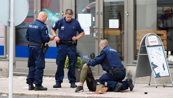 Police officers stand next to a person lying on the pavement in the Finnish city of Turku where several people were stabbed on August 18, 2017 - Sputnik International