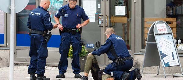 Police officers stand next to a person lying on the pavement in the Finnish city of Turku where several people were stabbed on August 18, 2017 - Sputnik International