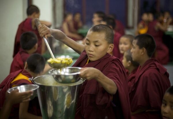 A young Buddhist monk serves food during dinner at the Kopan Monastery in Katmandu, Nepal. (File) A young Buddhist monk serves food during dinner at the Kopan Monastery in Katmandu, Nepal. (File) - Sputnik International