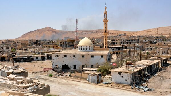 Smoke rising from buildings behind a mosque in the central Syrian town of Al-Sukhnah - Sputnik International