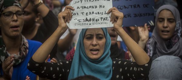 A woman holds a banner reading in Spanish: I am Muslim and Catalan, not a terrorist. Islam is Peace, during a protest by the Muslim community to condemn the vehicle attacks, in Barcelona, Spain - Sputnik International