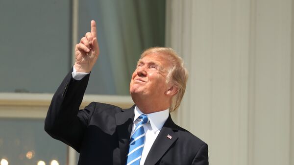 President Donald Trump points skyward before donning protective glasses to view the solar eclipse, Monday, Aug. 21, 2017, at the White House in Washington . - Sputnik International